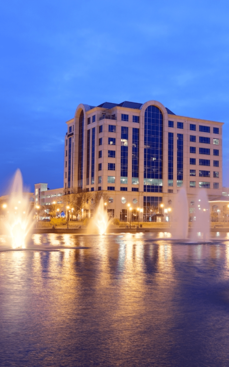 a beautiful fountain in the middle of a city, surrounded by tall buildings